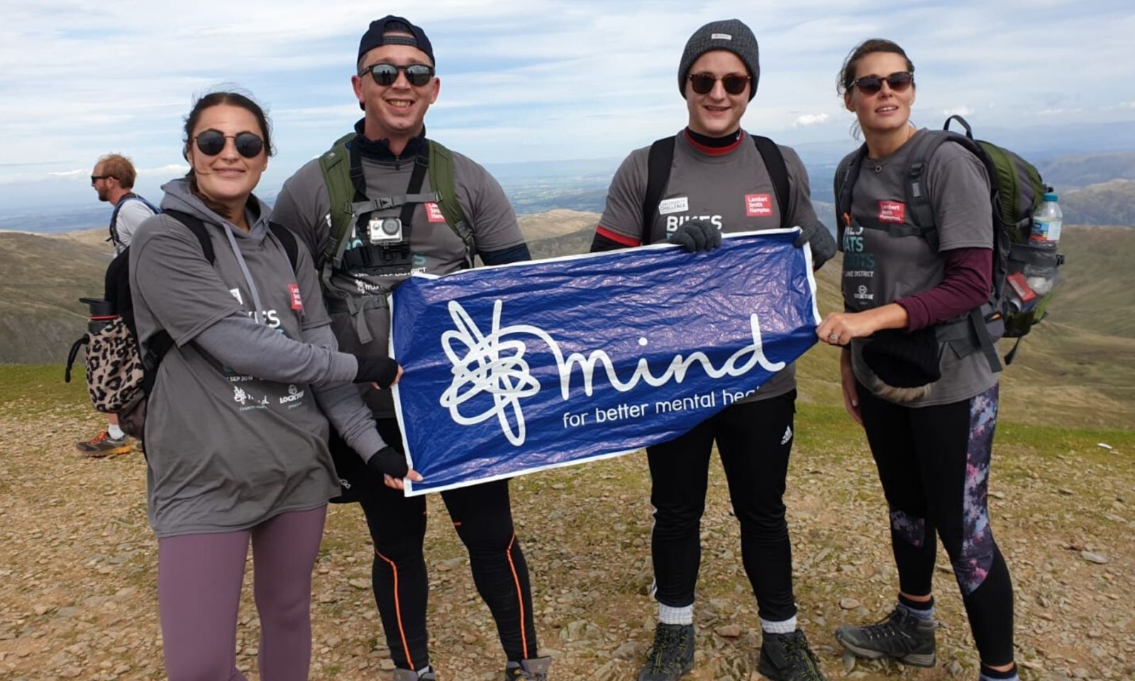 4 people standing on a mountain during a challenge event.