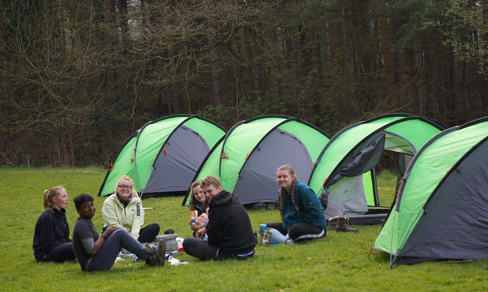 DofE group sitting around their tents cooking on stoves