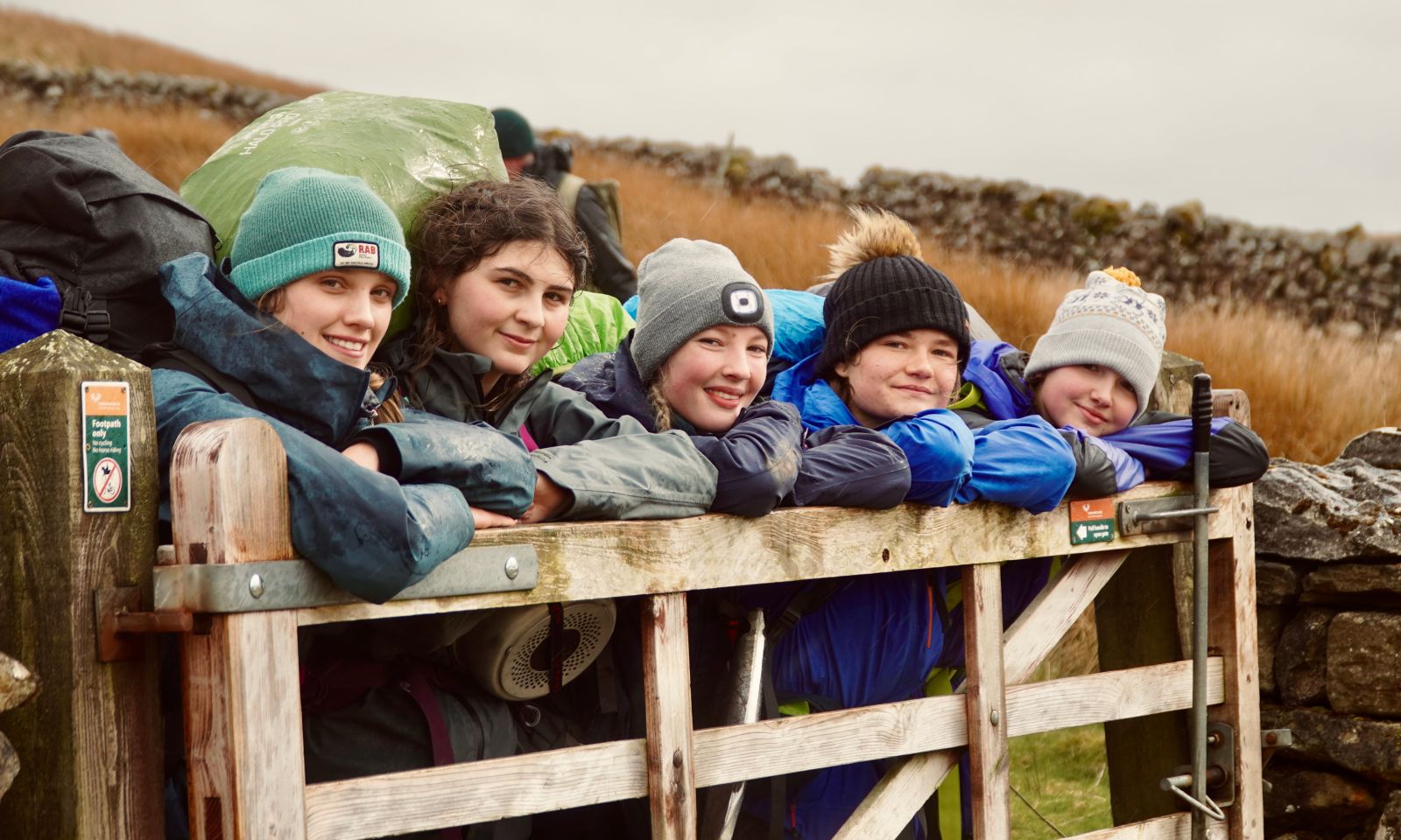 Gold DofE group taking a rest on a gate during their expedition