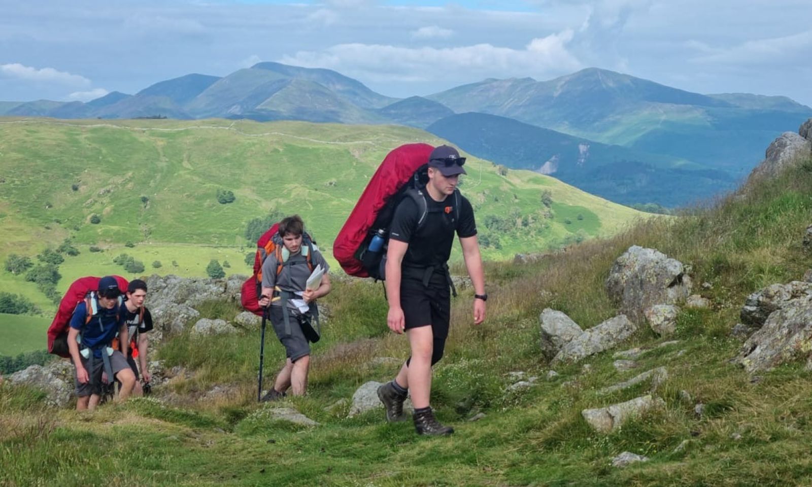 Boys DofE group walking up hill and navigating