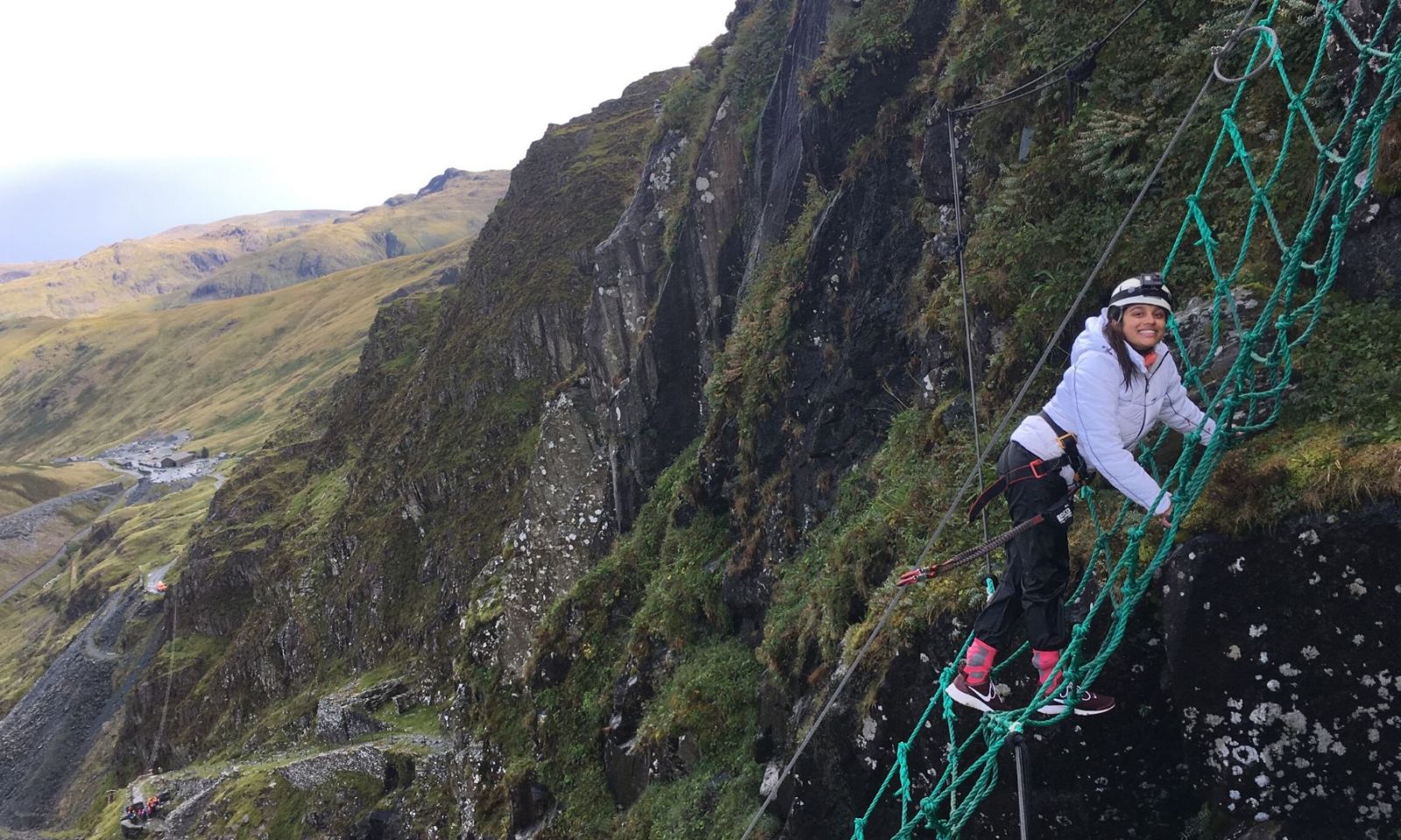 Girl climbing a rope net on the Via Ferrata at Honister Slate Mine.