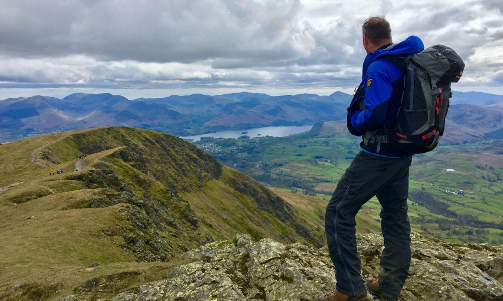 The Adventure Element DofE instructor waiting for his group to arrive, looking out over the mountains with his group in the distance