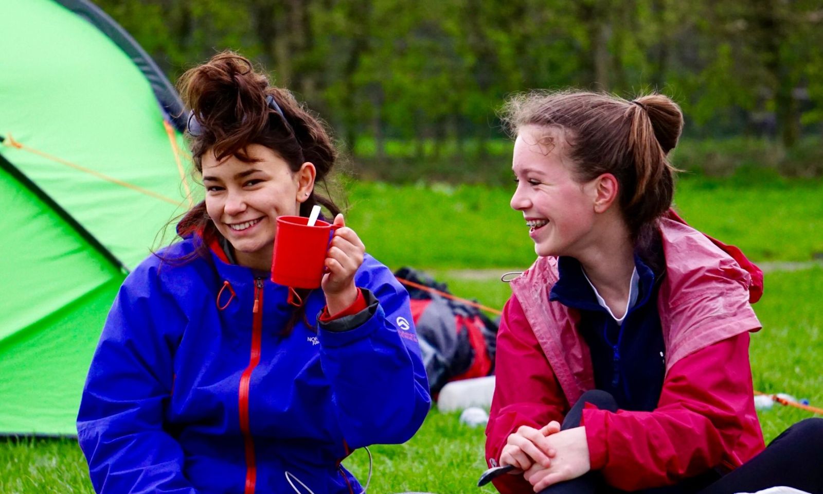 2 girls on their DofE expedition smiling and having fun.