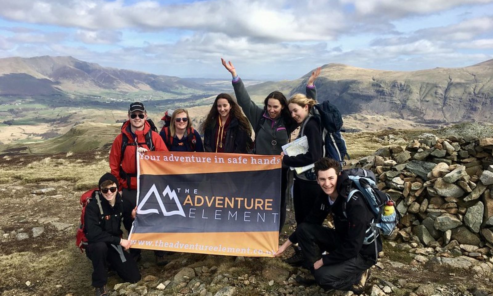 participants holding the adventure element banner at summit